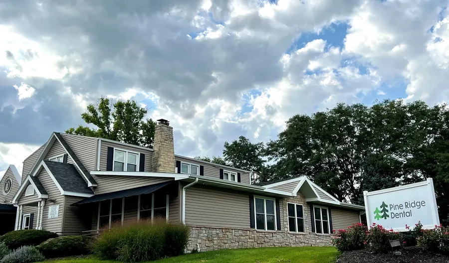 The Edgewood office on South 56th Street, a house-style building with a stone chimney and the Pine Ridge Dental sign on the lawn.