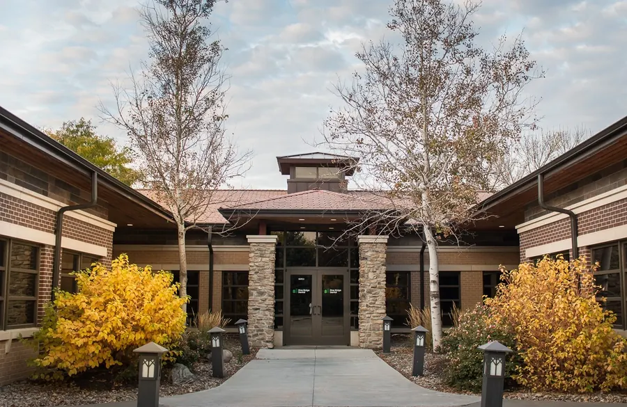 The entrance to the Wilderness Ridge office, brick and stone with autumn shrubs either side of the walk.